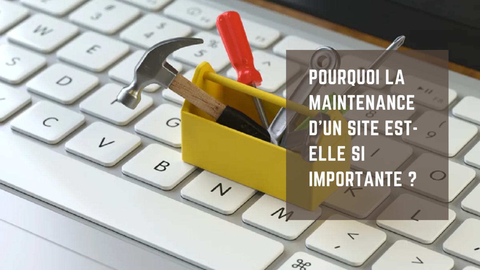 Petite boîte à outils posée sur un clavier d’ordinateur, symbolisant la maintenance d’un site web