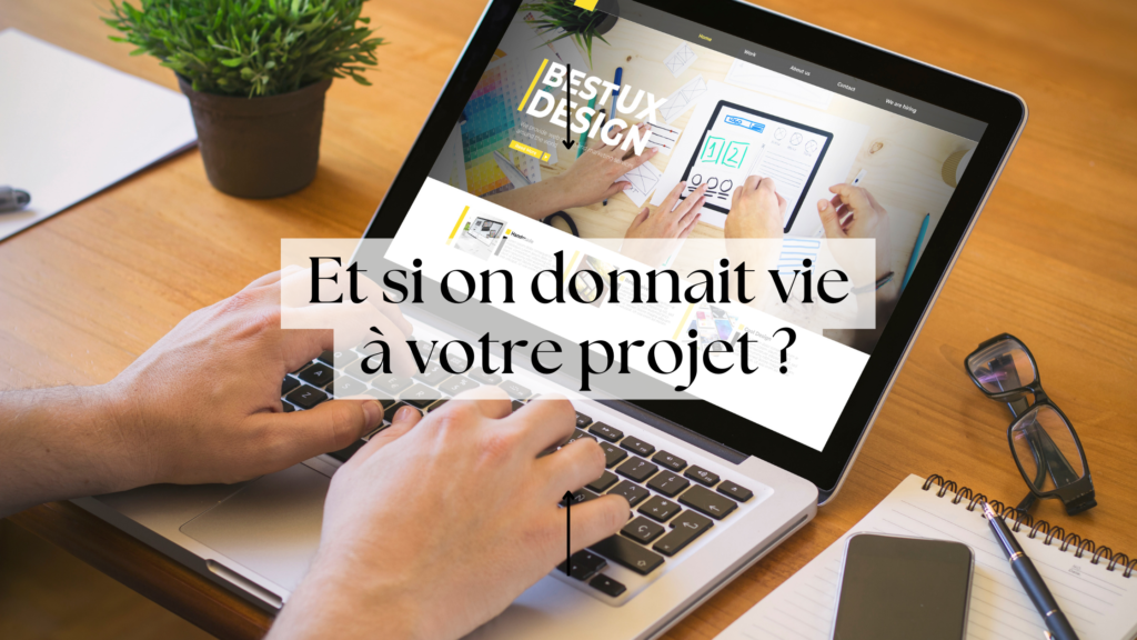 deux mains sur le clavier d'un ordinateur portable avec lunette, bloc-notes, stylo à coté sur la table