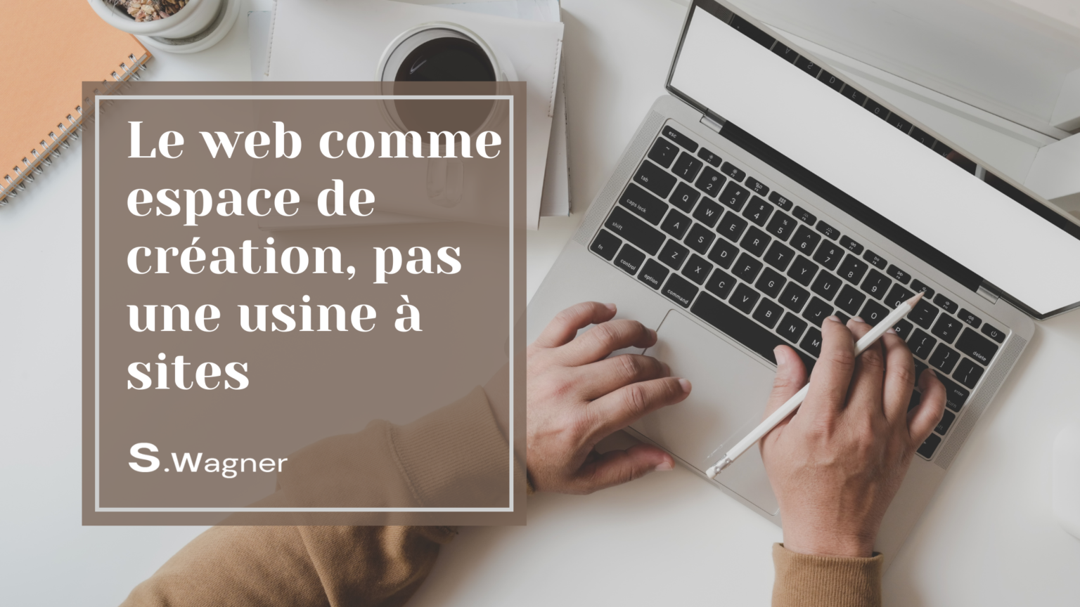 main qui tient un crayon blanc et qui tape sur un clavier d'ordinateur portable